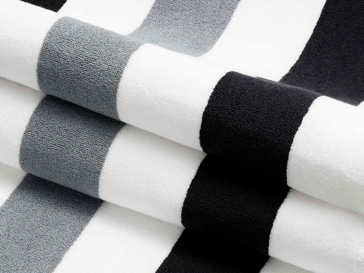 A close-up of a thick and soft, black, gray, and white striped cabana beach towel.
