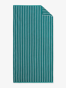 An oversized, green and white striped cabana beach towel laid out.