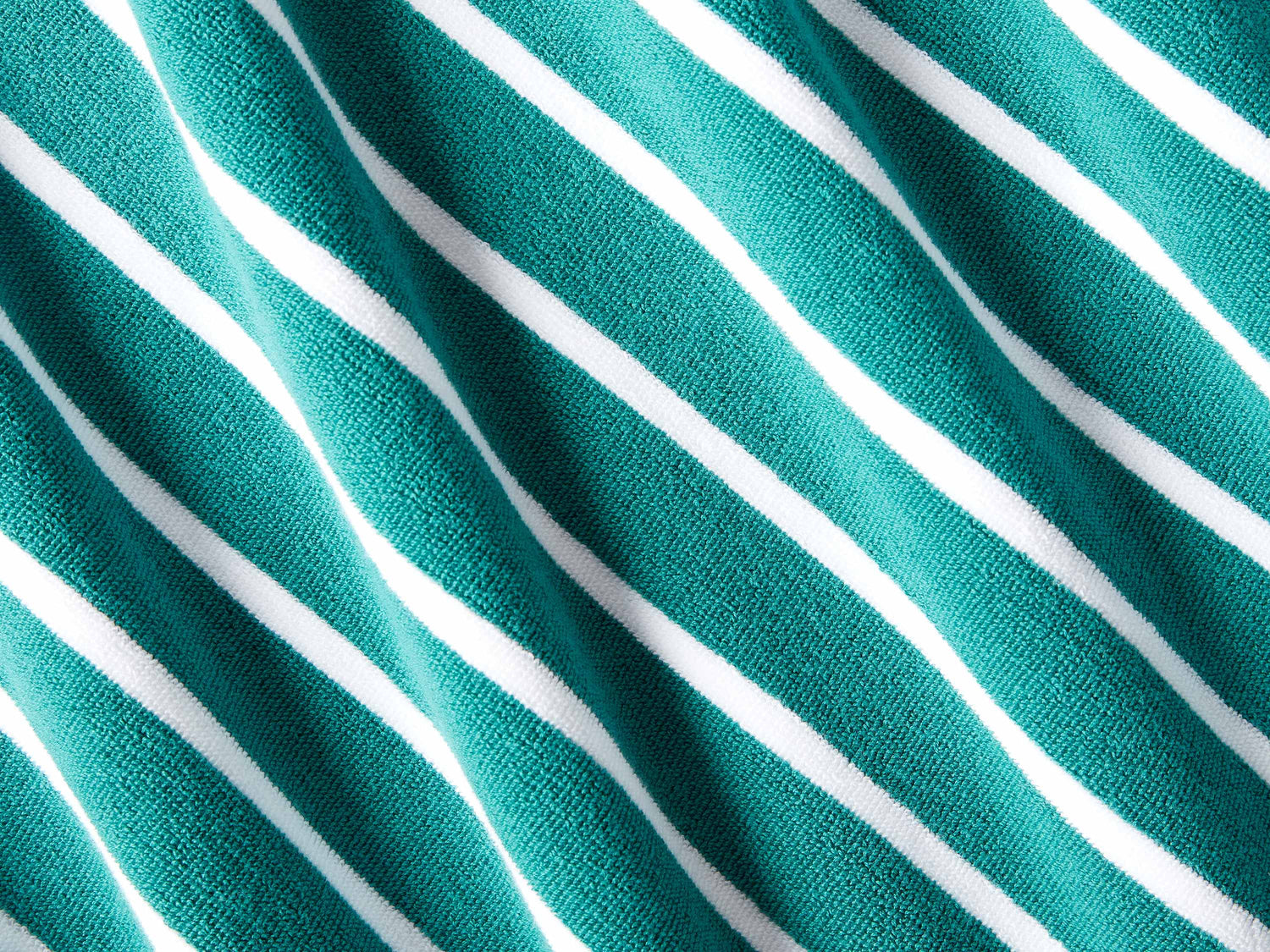 A close-up of a thick and soft, green and white striped cabana beach towel.