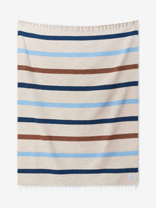 A photo of a white ivory, blue, and brown striped Mexican Blanket laid out.