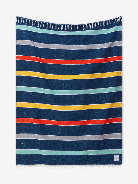 A multicolored blue, orange, and yellow striped Mexican Blanket with tassels laid out.