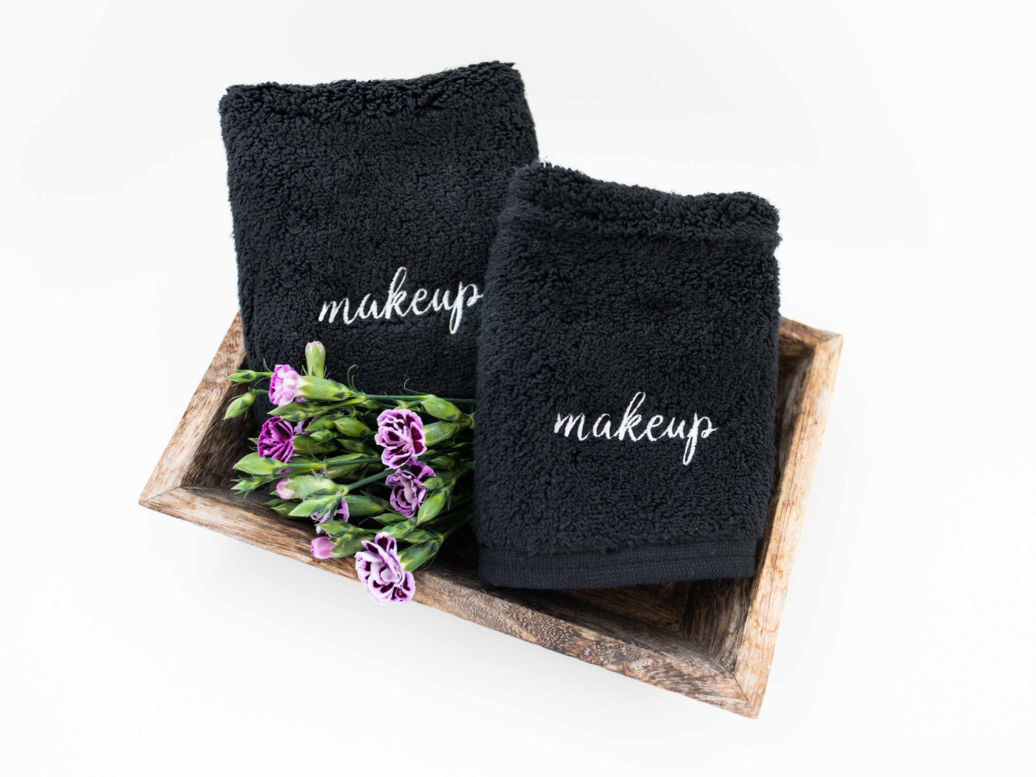 Pair of black makeup towels in modern bathroom with embroidery.