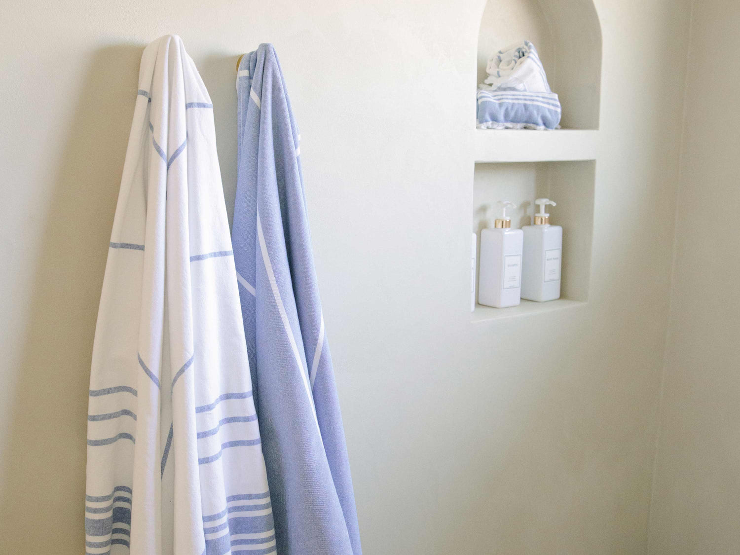 White and blue striped oversized Turkish towels in a modern bathroom.