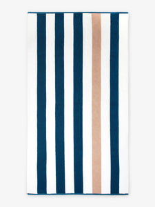 An oversized, blue, brown, and white striped cabana beach towel laid out.