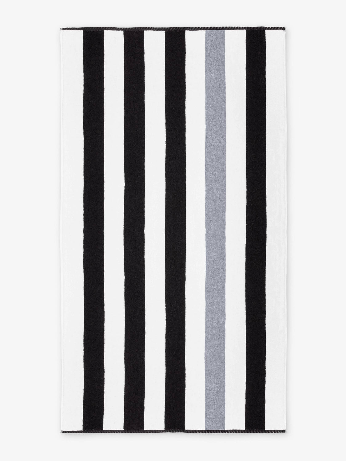 An oversized, black, gray, and white striped cabana beach towel laid out.