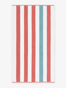 An oversized, orange, green, and white striped cabana beach towel laid out.