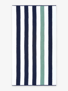 An oversized, blue, green, and white striped cabana beach towel laid out.