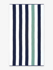 An oversized, blue, green, and white striped cabana beach towel laid out.