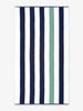 An oversized, blue, green, and white striped cabana beach towel laid out.
