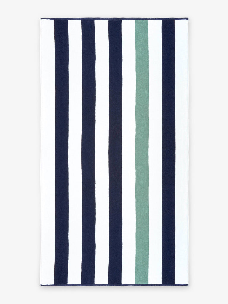 An oversized, blue, green, and white striped cabana beach towel laid out.