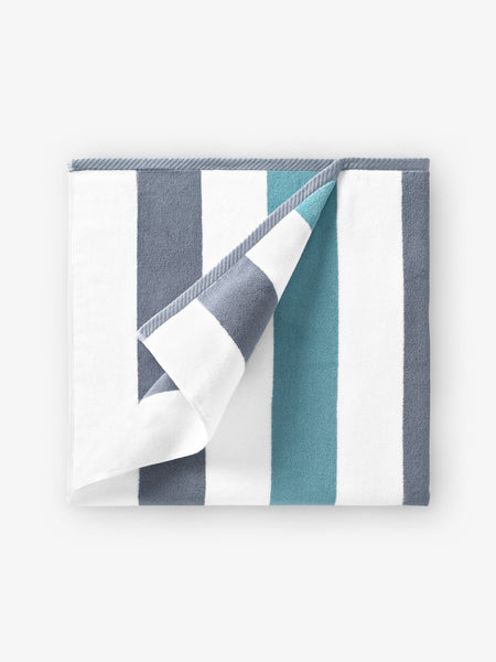 A folded gray, green, and white striped cabana beach towel.