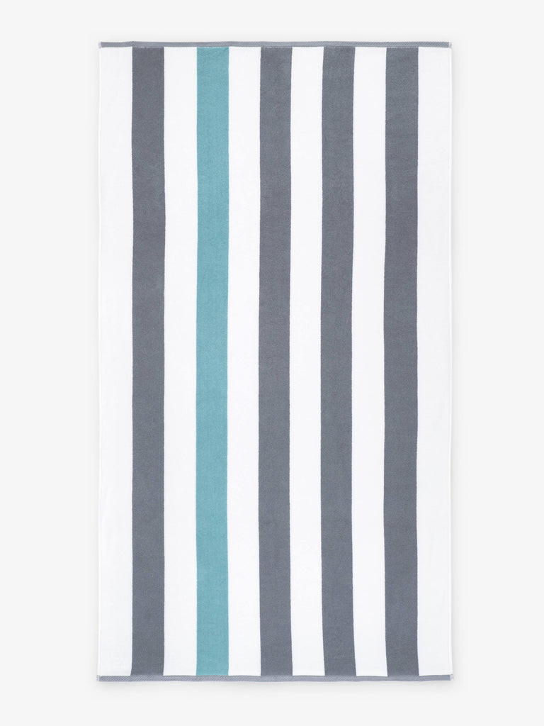 An oversized, gray, green, and white striped cabana beach towel laid out.