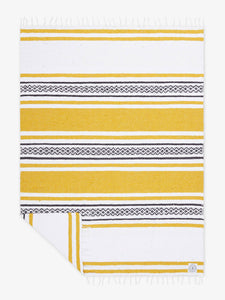 Oversized, traditional Mexican blanket in yellow and white striped pattern with white fringe spread out.