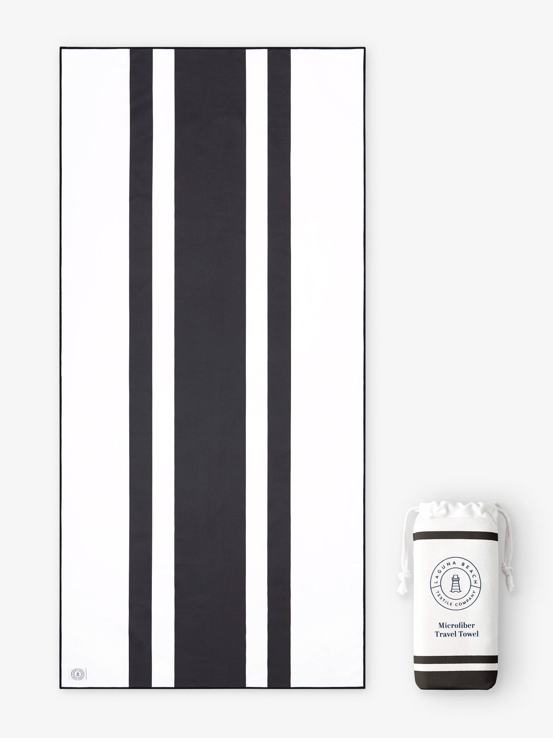 An oversized, quick drying black and white striped microfiber beach towel laid out next to a matching travel bag.