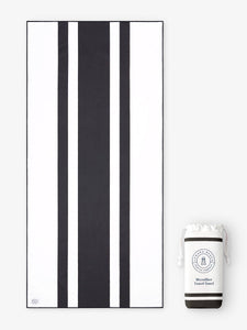 An oversized, quick drying black and white striped microfiber beach towel laid out next to a matching travel bag.