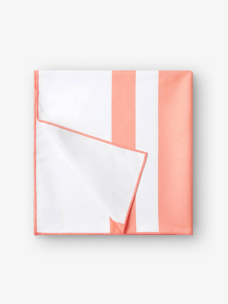 A folded quick drying, coral and white striped microfiber beach towel.