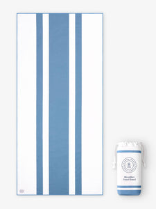 An oversized, quick drying light blue and white striped microfiber beach towel laid out next to a matching travel bag.