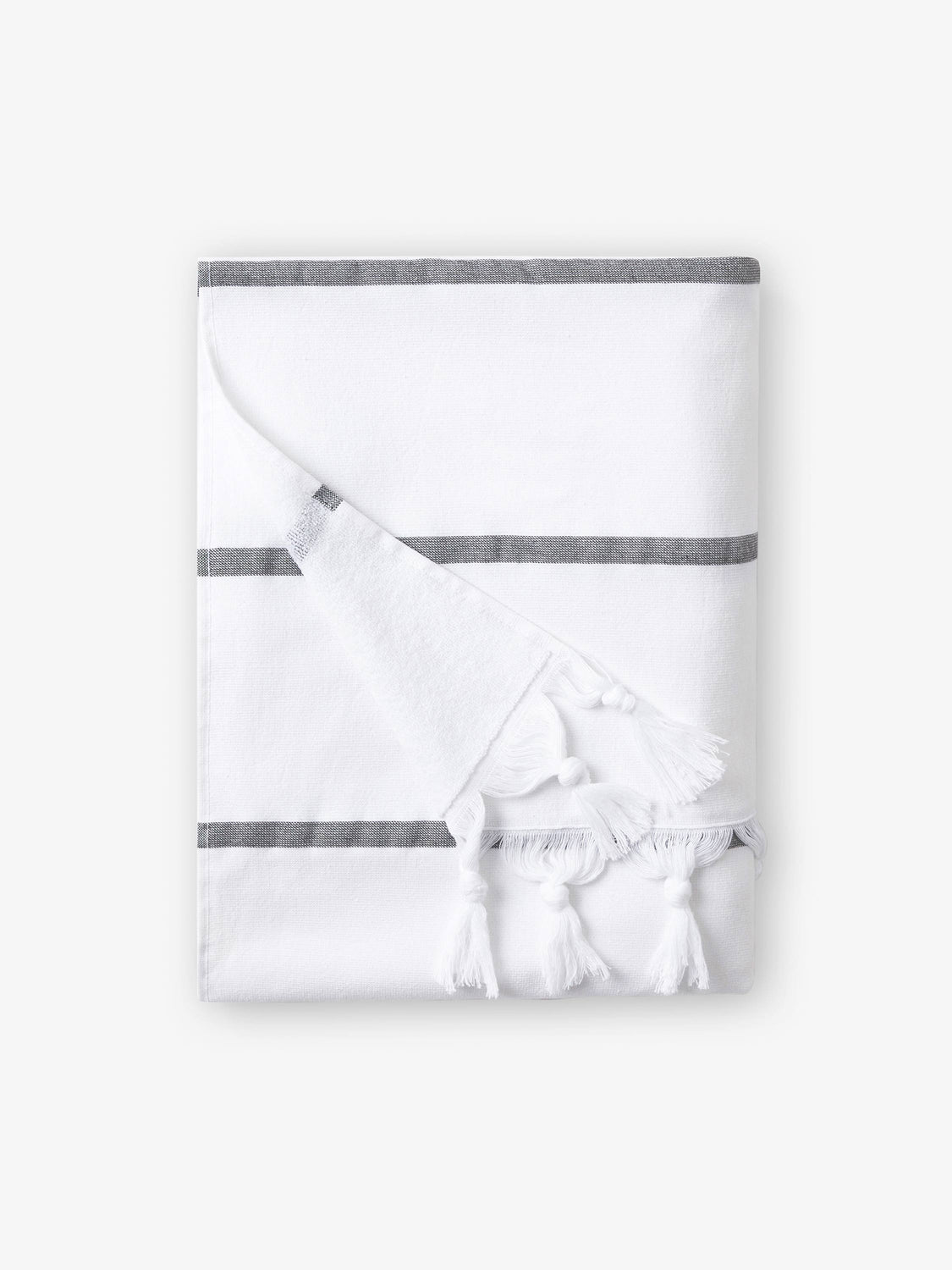 A folded white and gray striped Turkish towel with white fringe.