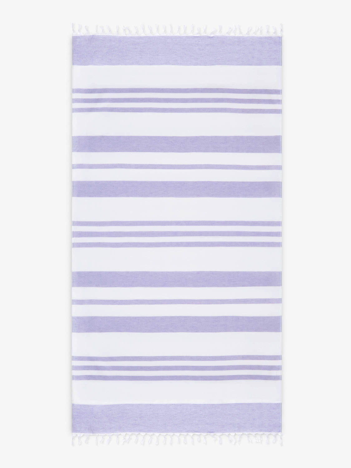 An oversized, white and purple striped Turkish cotton towel with white fringe laid out.