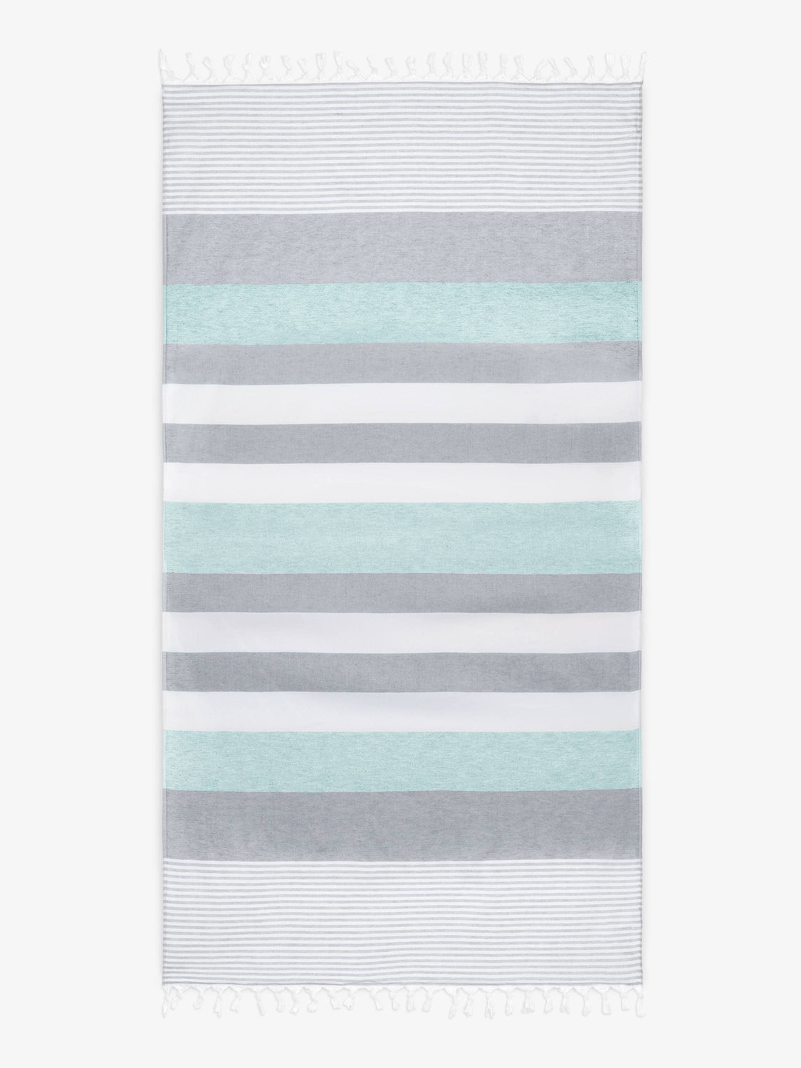 An oversized, teal and gray striped Turkish cotton towel with white fringe laid out.