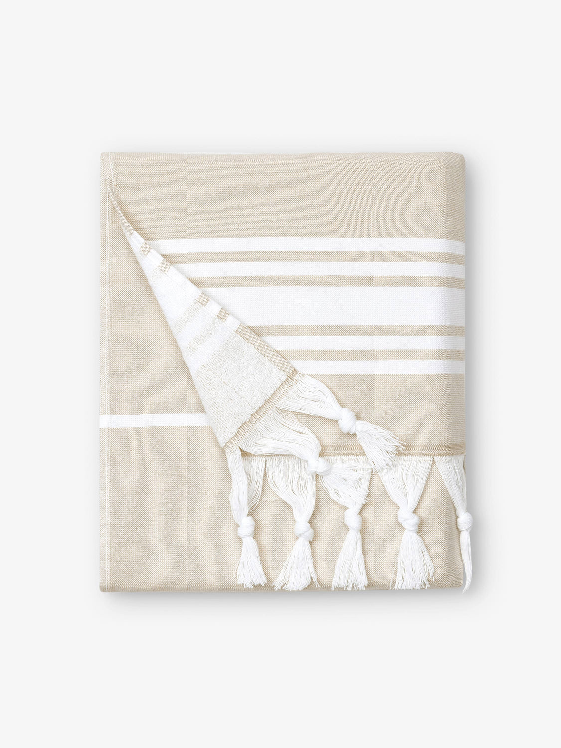 A folded white and tan striped Turkish towel with white fringe.