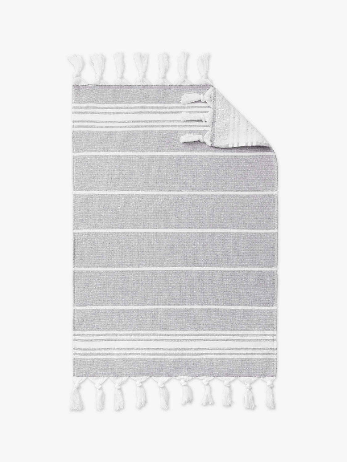 A stone gray and white striped Turkish cotton hand towel with white fringe laid out.