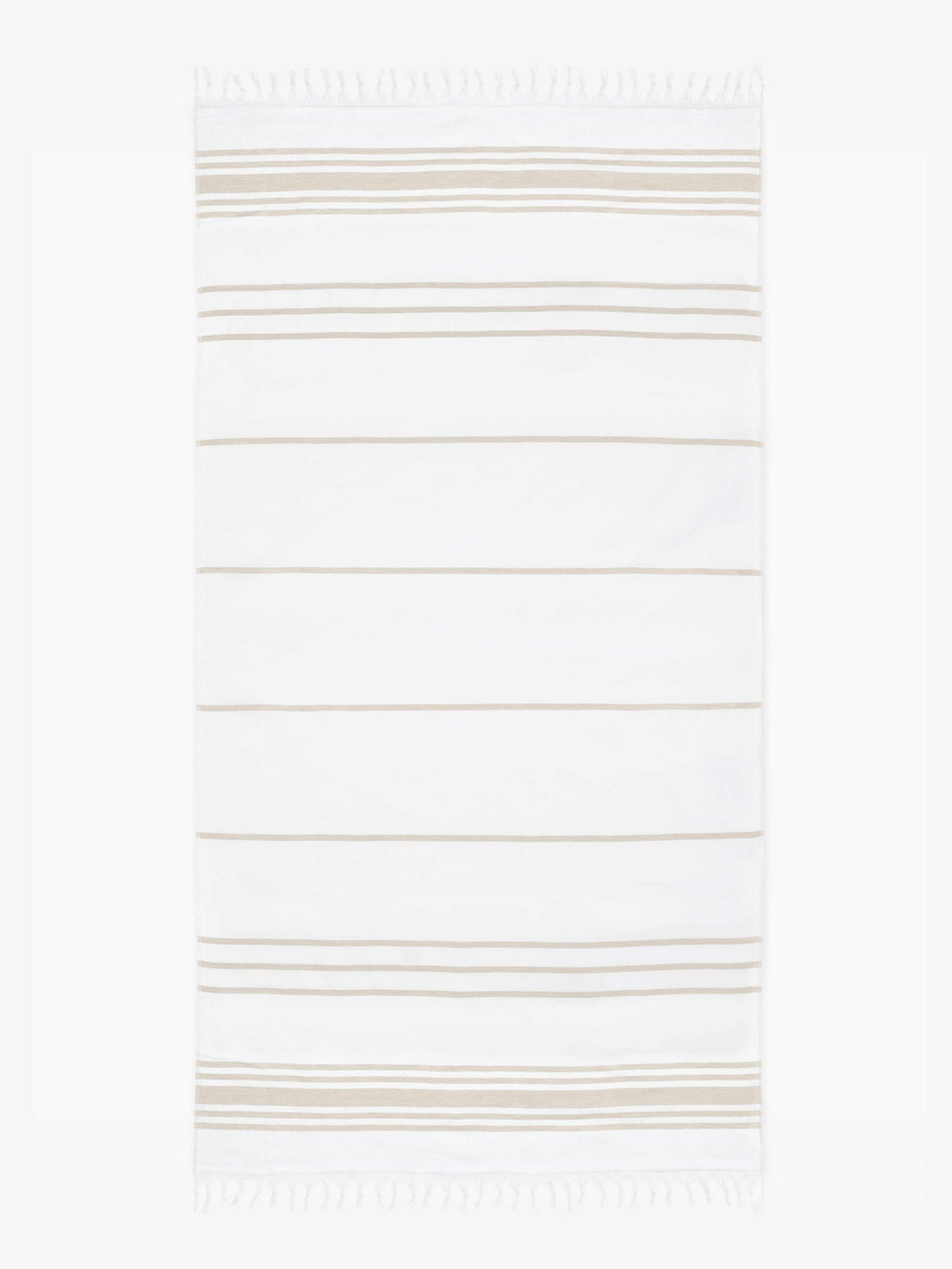 An oversized tan and white striped Turkish cotton towel with white fringe laid out.