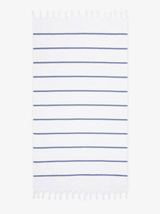 An oversized, navy and white striped Turkish cotton towel with white fringe laid out.