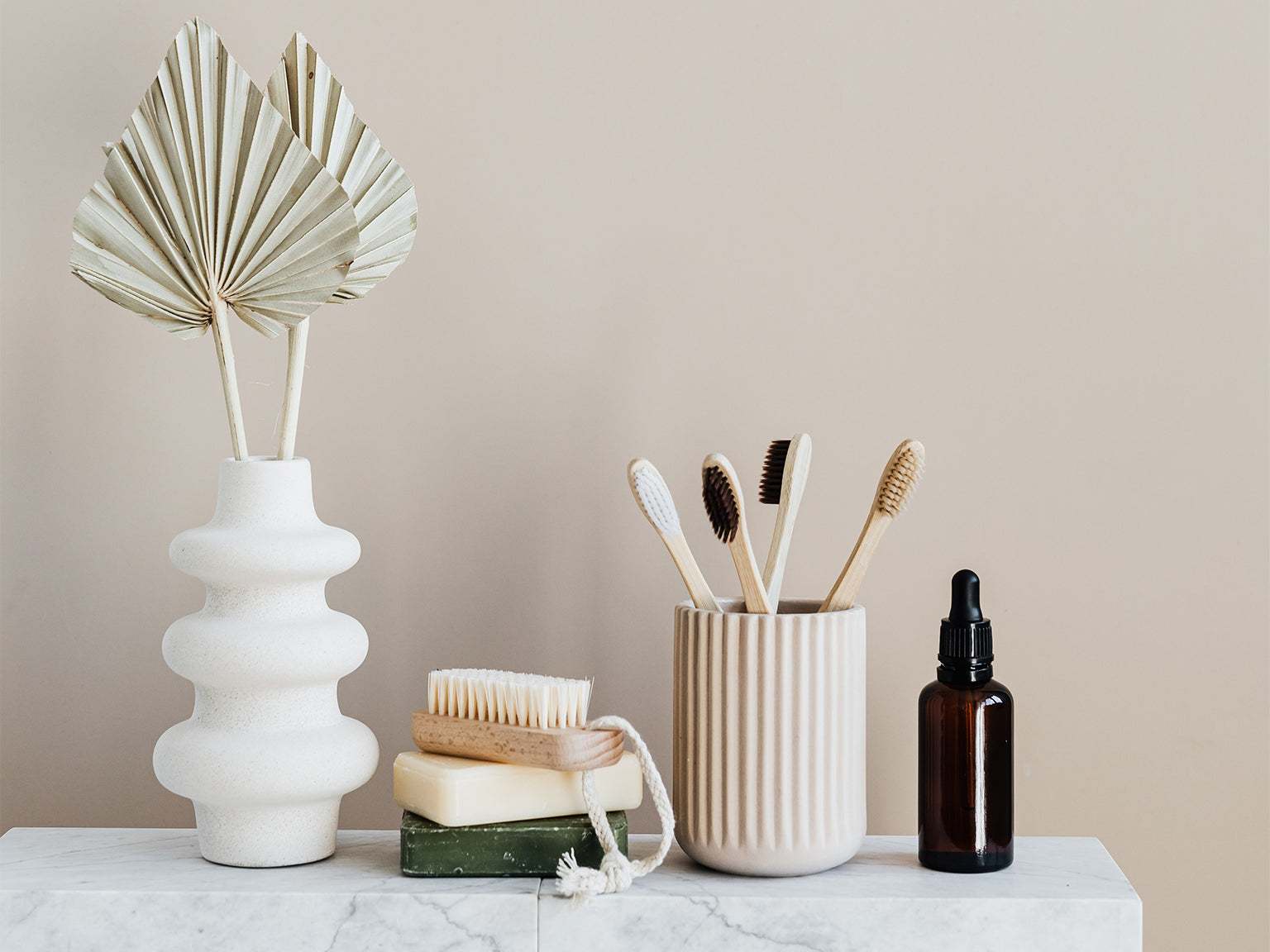 Wooden toothbrushes and eco friendly soap on a marble counter top.