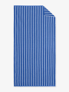 An oversized, blue and white striped cabana beach towel laid out.