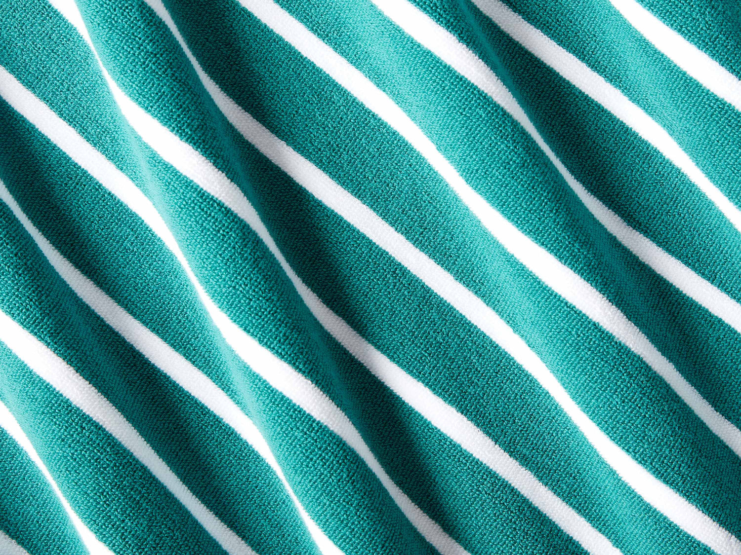 
      A close-up of a thick and soft, green and white striped cabana beach towel.
    