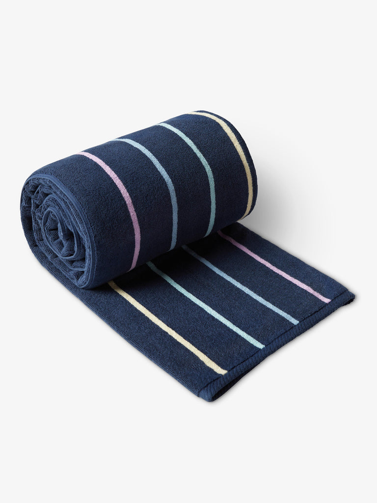 A rolled-up, navy blue, multicolor-striped cabana beach towel. 