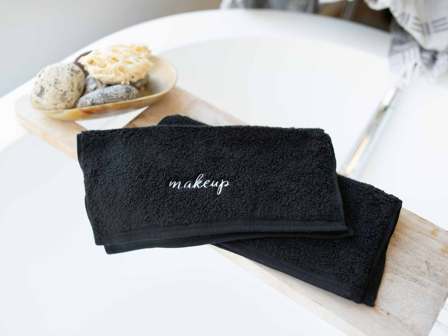 
      Pair of two soft black cotton makeup towels in modern luxury bathroom.
    