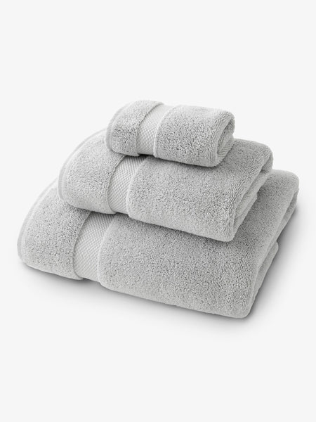 A set of gray bath, hand, and wash towels folded and stacked on one another.