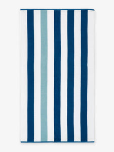 An oversized, blue, green, and white striped cabana beach towel laid out.
