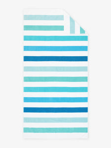 An oversized, striped cabana beach towel with shades of blue and green laid out.