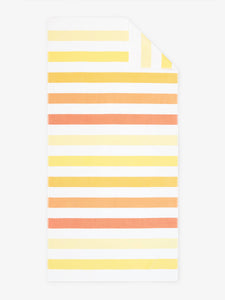 An oversized, yellow, orange, and white striped cabana beach towel laid out.