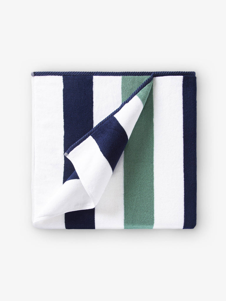 A folded blue, green, and white striped cabana beach towel.