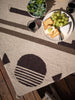 Picnic spread on top of brown and tan oversized Mexican throw blanket.