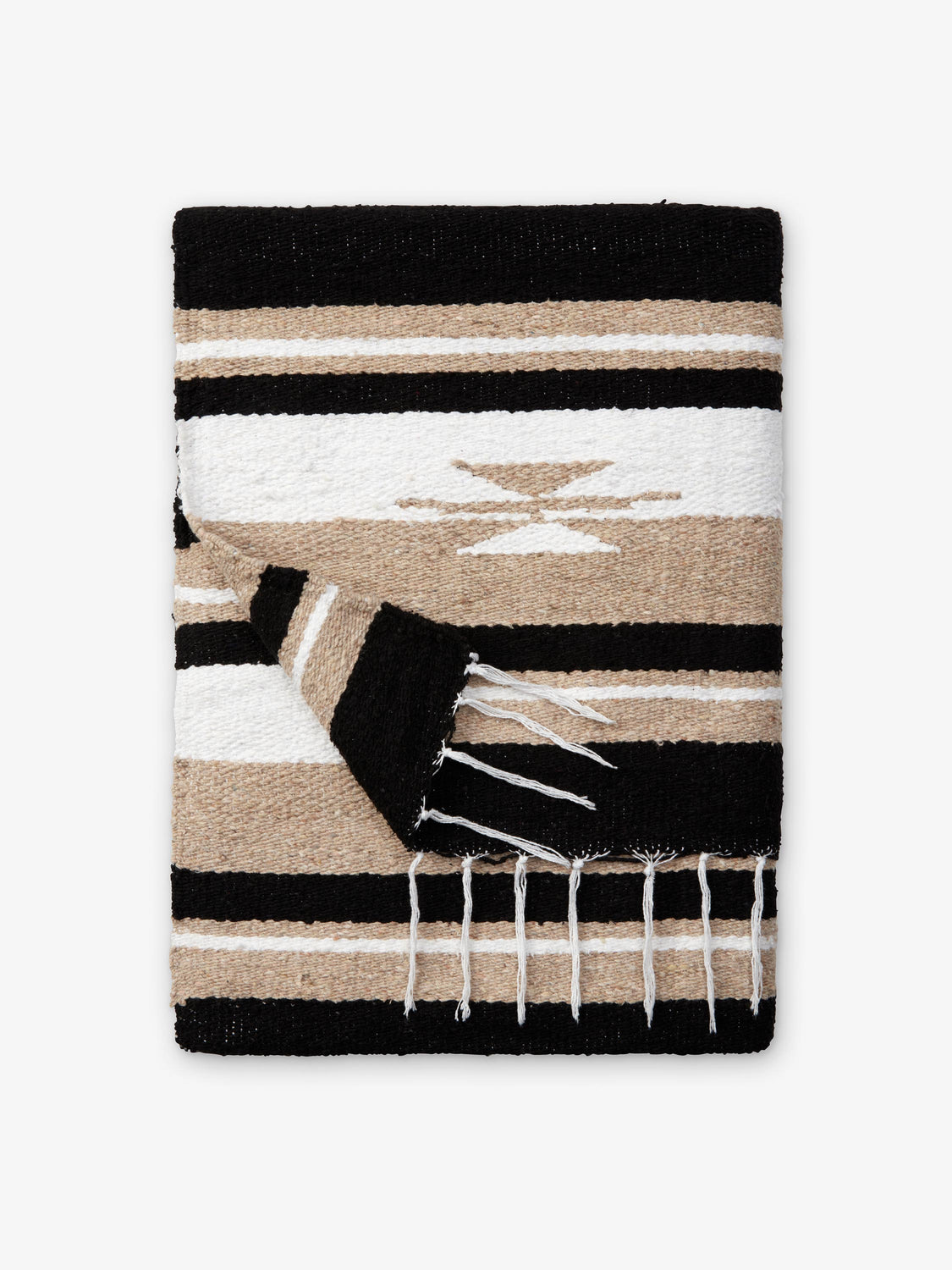 A folded traditional, hand-woven Mexican blanket in black, tan, and white pattern with fringe.