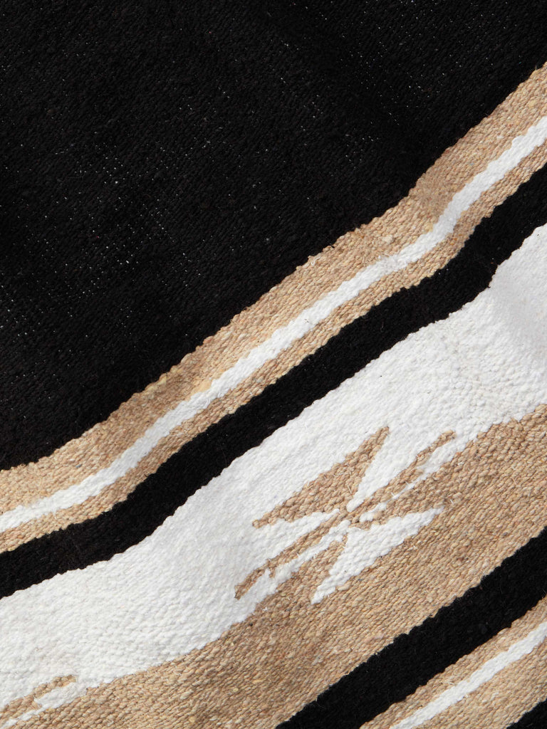Close-up of a traditional black, tan, and white patterned Mexican blanket.