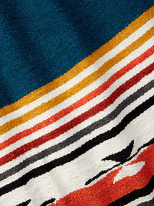 Close-up of a traditional navy blue, red, and yellow patterned Mexican blanket.