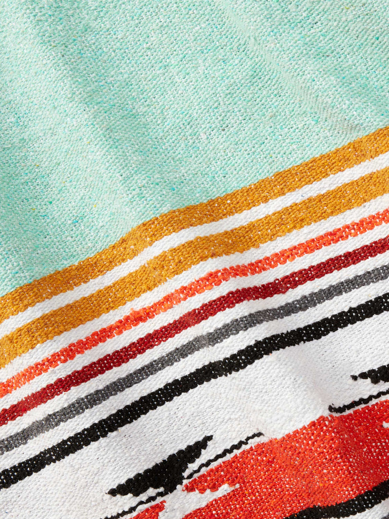 Close-up of a traditional green, red, and yellow patterned Mexican blanket.