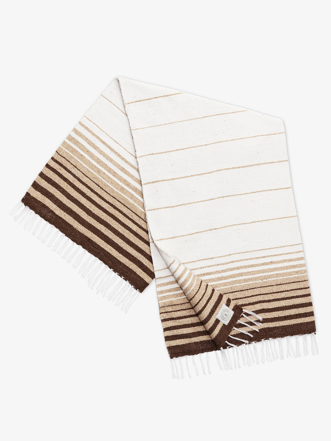 A folded traditional, hand-woven Mexican blanket in brown, tan, and white stripe pattern with fringe.