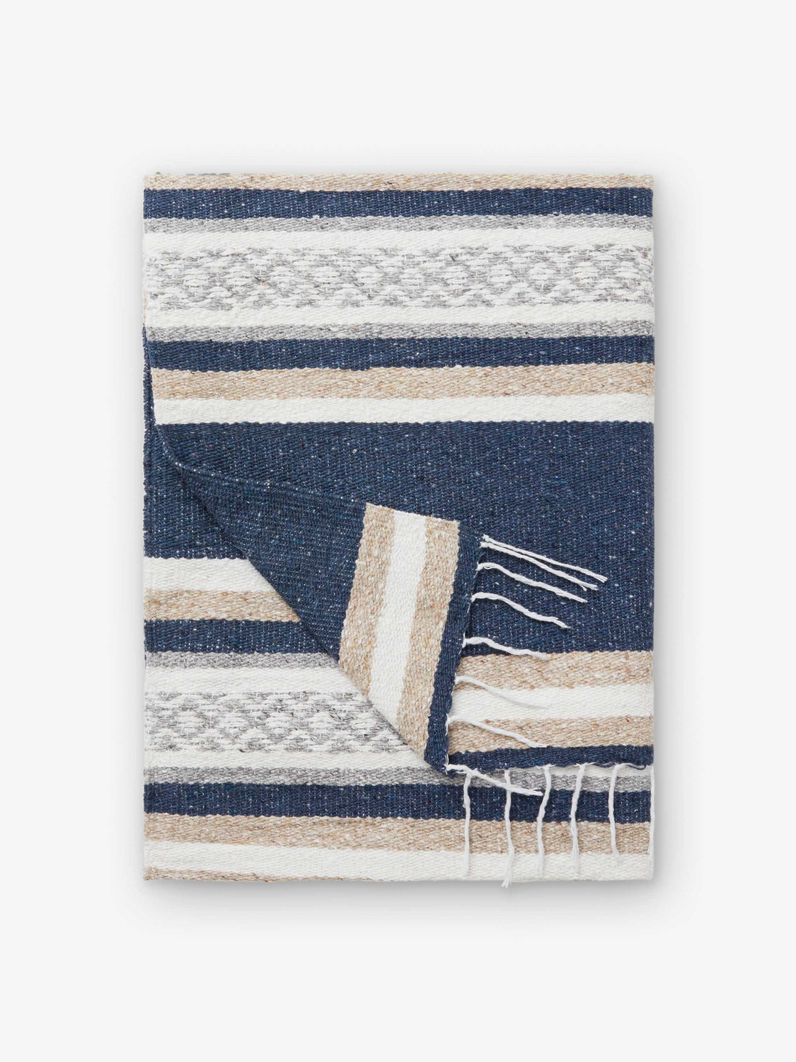 A folded traditional, hand-woven Mexican blanket in gray, tan, and white pattern with fringe.