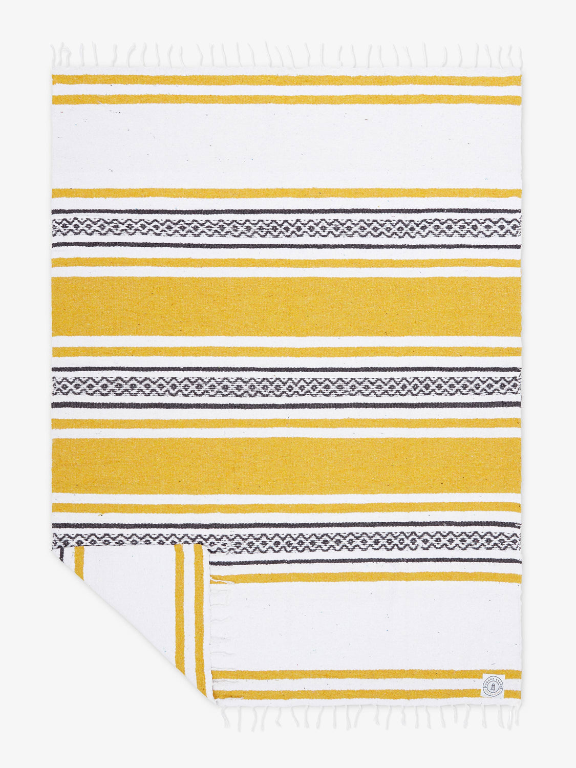 Oversized, traditional Mexican blanket in yellow and white striped pattern with white fringe spread out. 