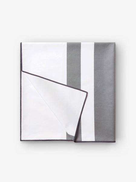 A folded quick drying, gray and white striped microfiber beach towel.
