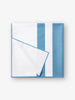 A folded quick drying, light blue and white striped microfiber beach towel.