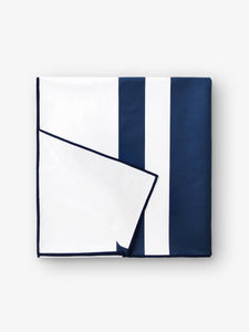 A folded quick drying, navy blue and white striped microfiber beach towel.