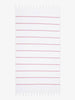 An oversized, white and pink striped Turkish cotton towel with white fringe laid out.
